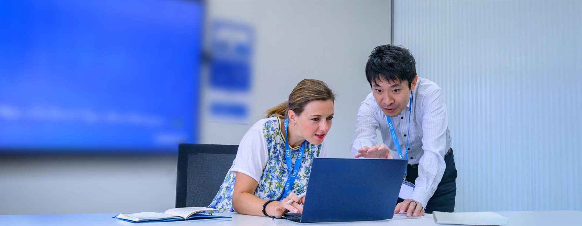 Professional executives engages in a strategy session with digital tools, representing AI and digital business transformation. - IMD Business School