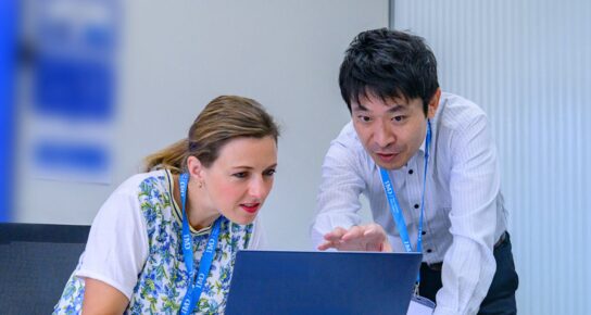 Professional executives engage in a strategy session with digital tools, representing AI and digital business transformation. - IMD Business School