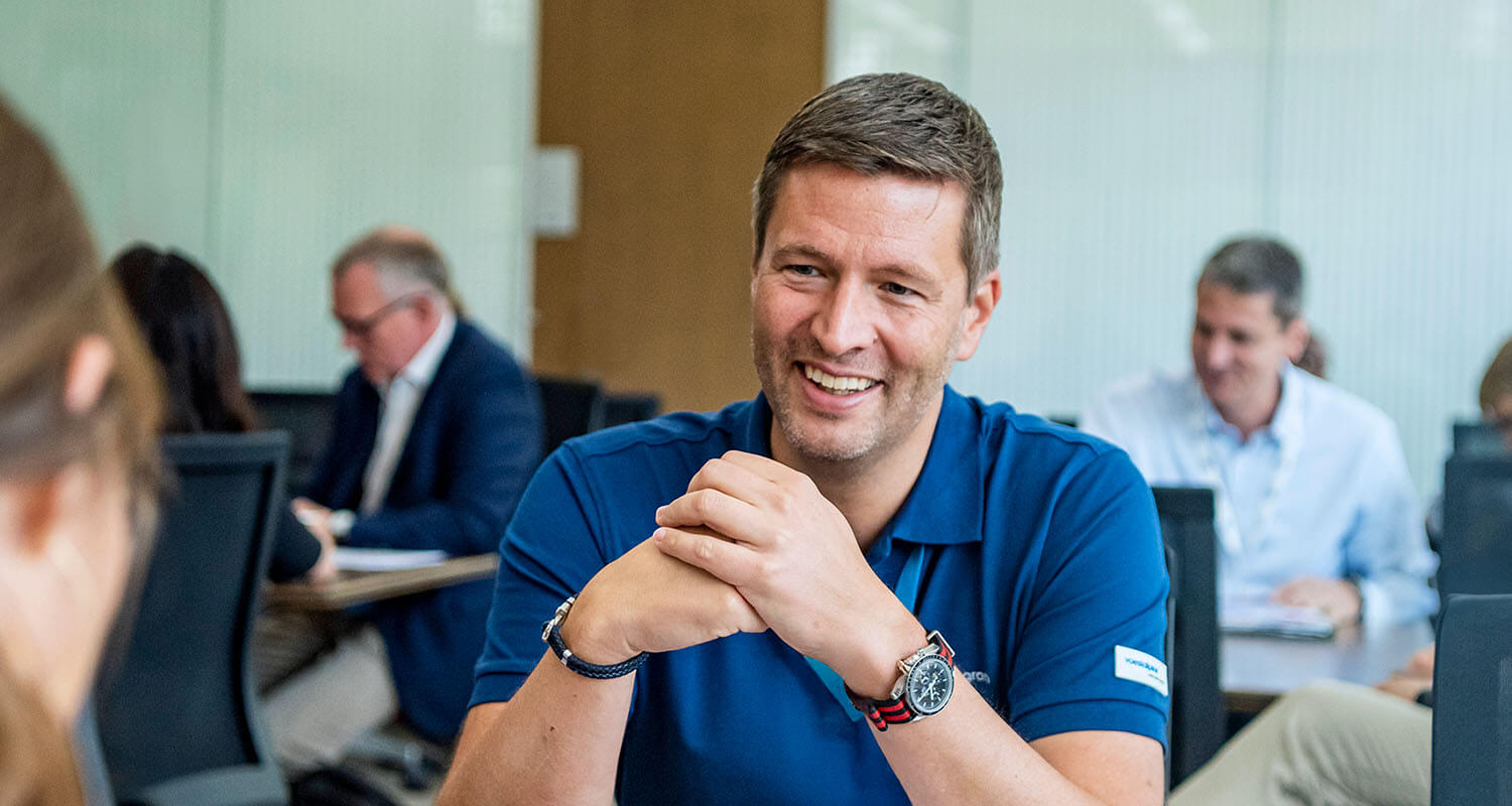 Group of business professionals in discussion during a sustainability-focused executive education program at IMD - IMD Business School